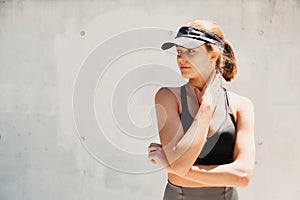 Portrait of a beautiful young sporty woman with visor cap in a hot day