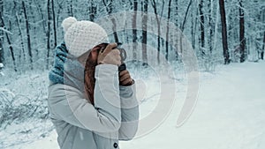 Portrait of beautiful young tourist photographer girl taking pictures in forest