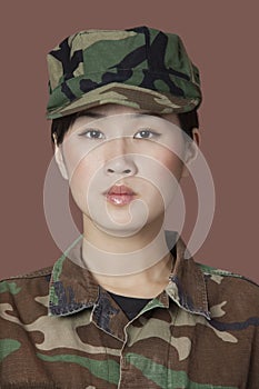 Portrait of beautiful young US Marine Corps soldier in camouflage clothing over brown background