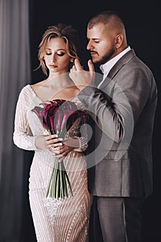 Portrait of beautiful young wedding couple at black background