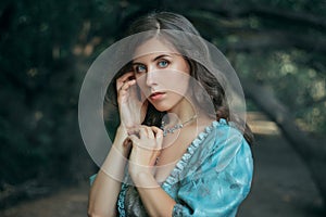 Portrait of a beautiful young woman in a 19th century dress in a mysterious forest. Mystical atmosphere. The photo