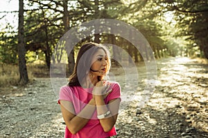 Portrait of beautiful young woman in against the sun background