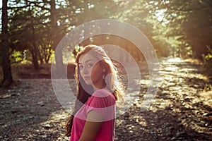 Portrait of beautiful young woman in against the sun background