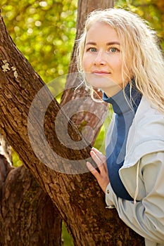 Portrait of a beautiful young woman in an autumn park on a yellow background with leaves