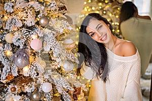 Portrait of a beautiful young woman on the background of a Christmas tree, the concept of new year holidays