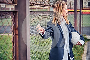 Portrait of beautiful young woman with ball near goal net at stadium