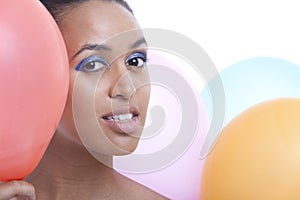 Portrait of beautiful young woman with balloons against white background