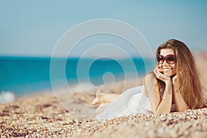 Portrait of a beautiful young woman on the beach in the sand