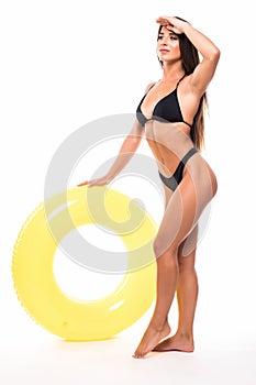 Portrait of beautiful young woman in bikini playing with float isolated on white background