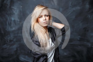Portrait of a beautiful young woman with blond hair in a black s