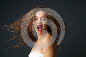 Portrait of a beautiful young woman with blowing hair laughing