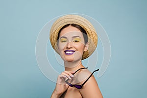 Portrait of beautiful young woman with bright make-up isolated on blue studio background
