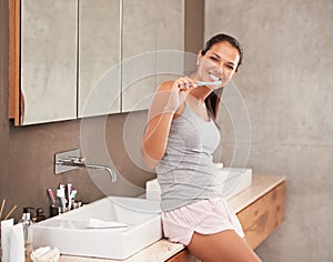 No cavities for me. A portrait of a beautiful young woman brushing her teeth in her bathroom.