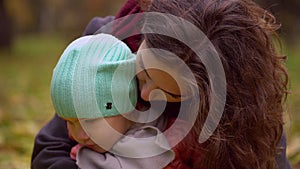 Portrait of beautiful young woman with a child in an autumn park. Portrait of two, young mother and daughter. slow