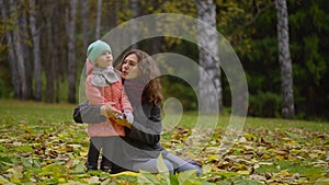 Portrait of beautiful young woman with a child in an autumn park. Portrait of two, young mother and daughter. slow