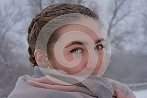 Portrait of  beautiful young woman close-up. Lady with green eyes in winter outdoors snowfall
