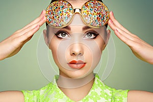 Portrait of beautiful young woman with colored glasses
