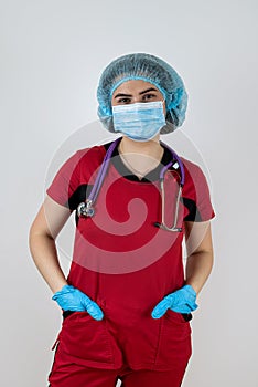 Portrait of beautiful young woman doctor wear red uniform, protective mask and rubber gloves