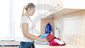 Portrait of beautiful young woman doing laundry at home