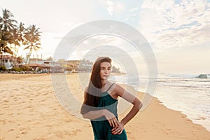 Portrait of beautiful young woman in dress on the beach. Pretty girl on tropical beach. Freedom concept, holiday,