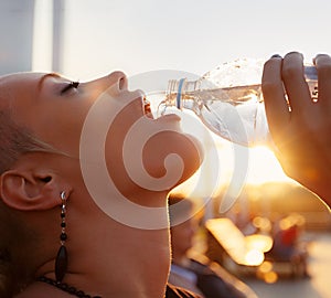 Portrait of beautiful young woman drinking water outdoors
