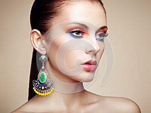 Portrait of beautiful young woman with earring. Jewelry and accessories