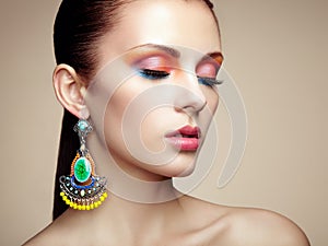 Portrait of beautiful young woman with earring. Jewelry and accessories