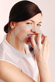 Portrait of beautiful young woman eating an apple