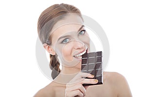 Portrait of a beautiful young woman eating a chocolate bar.