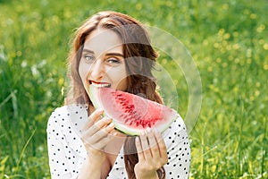 Portrait of a beautiful young woman eating watermelon.