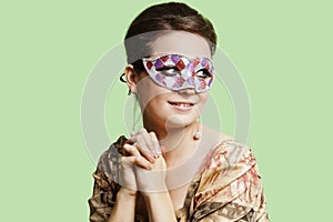 Portrait of beautiful young woman with eye mask day dreaming against green background