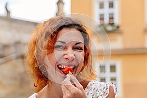 Portrait of the beautiful young woman with fresh red strawberries. Girl enjoy eating appetizing and juicy strawberry