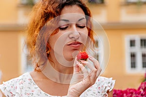 Portrait of the beautiful young woman with fresh red strawberries. Girl enjoy eating appetizing and juicy strawberry. Healthy food