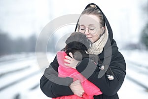 Portrait of a beautiful young woman with a german boxer puppy on a winter walk