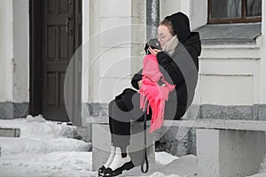 Portrait of a beautiful young woman with a german boxer puppy on a winter walk