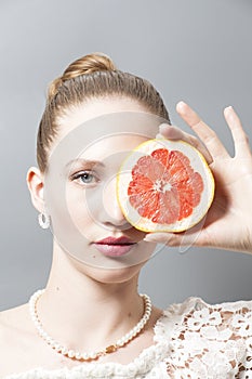 Portrait of Beautiful young woman with grapefruit in her hand