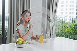 Portrait of beautiful young woman having breakfast in the kitchen
