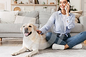 Portrait of beautiful young woman with her dog using mobile