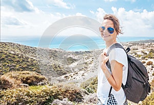 Portrait of a beautiful young woman hipster traveler against the