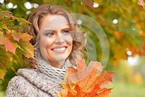 Portrait of beautiful young woman holding autumn leaves