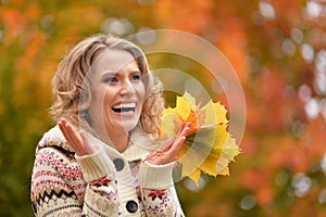 Portrait of beautiful young woman holding autumn leaves