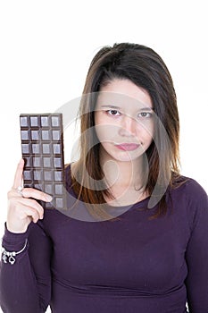 Portrait of beautiful young woman holding chocolate bar sad