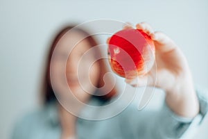 Portrait of a beautiful young woman holding a red apple against a gray wall background. Healthy food diet. Apple vitamin