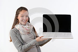 portrait of a beautiful young woman holding up a laptop and smiling against a white background