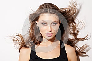 Portrait beautiful young woman with long brown hair. Pretty model poses at studio.