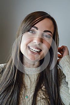 Portrait of a beautiful young woman with long brown hair smiling happily