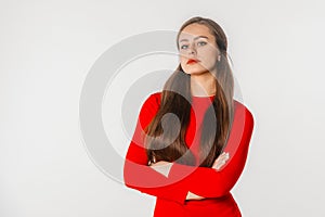 Portrait of beautiful young woman with long hair. Confident businesswoman with crossed arms looking at camera, standing against