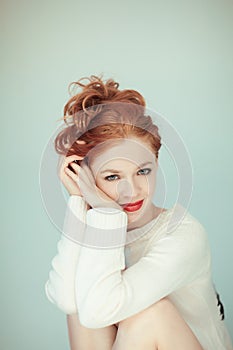 Portrait of a beautiful young woman with long red curly hair and perfect make up