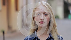 Portrait of beautiful young woman looking to camera. Crop view of blond hair woman wearing blue plaid shirt while