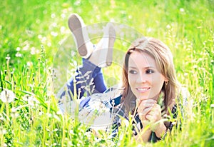 Portrait of a beautiful young woman lying in the grass